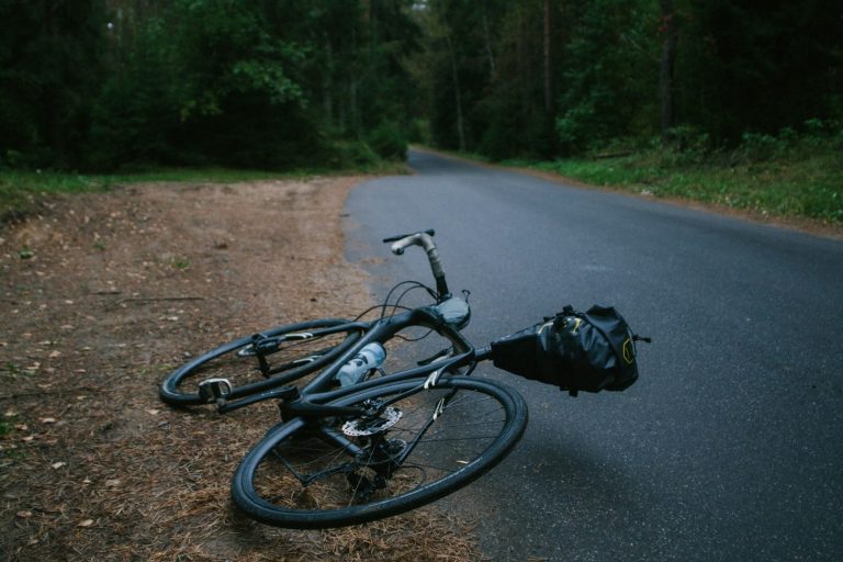 Dein lückenloser Unfallschutz in der Freizeit und im Beruf Ein liegendes Bike am Straßenrand zeigt das Risiko von Freizeitunfällen und die Notwendigkeit eines privaten Unfallschutzes für Angestellte.